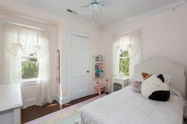 a bedroom with a bed a window and a chandelier