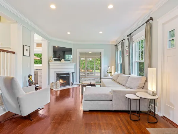 a living room with fireplace furniture and a wooden floor