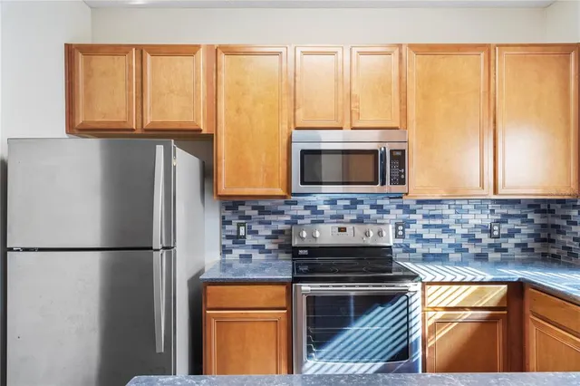 a kitchen with stainless steel appliances a stove sink and microwave