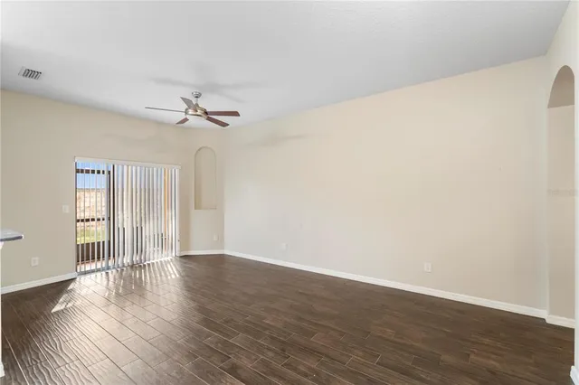 a view of wooden floor and chandelier fan in a room