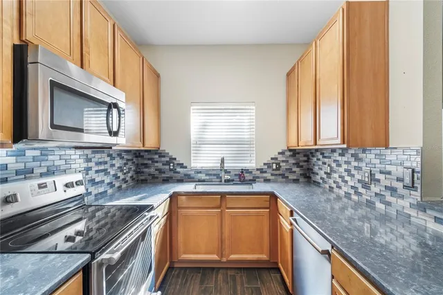 a kitchen with a sink stove top oven and microwave