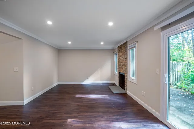 a view of empty room with wooden floor and fireplace