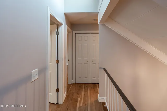 a view of a hallway with wooden floor and staircase
