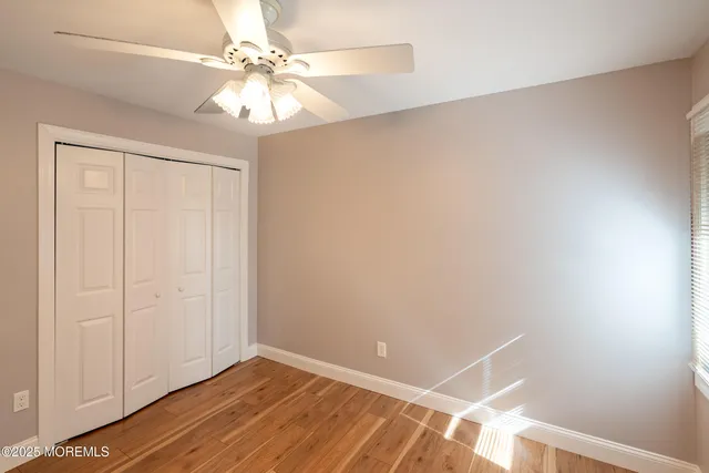 an empty room with windows and fan