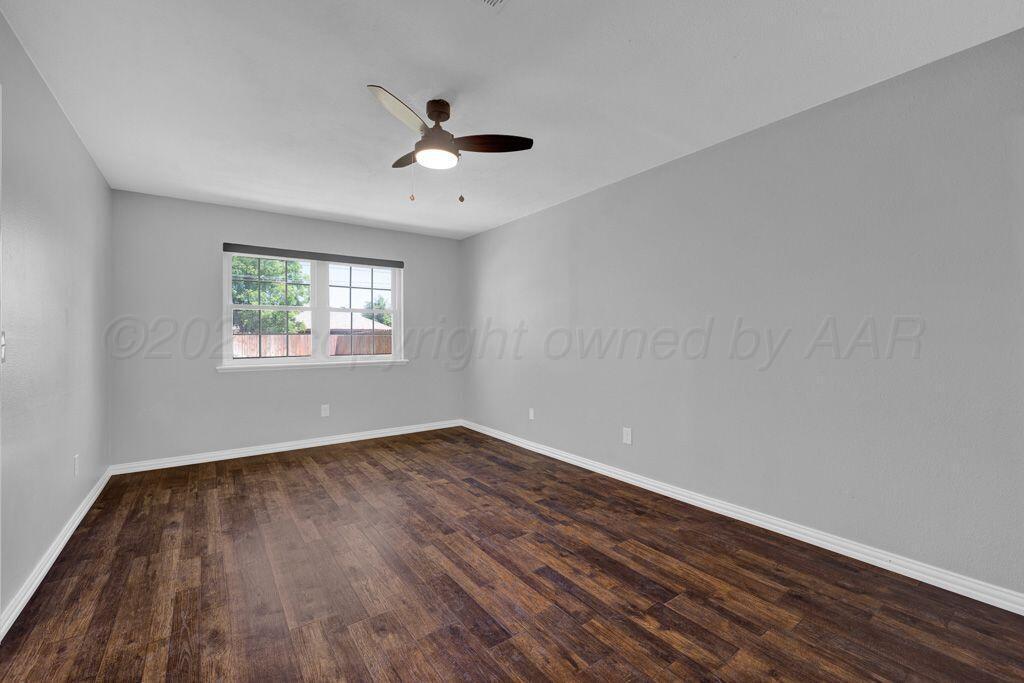 7935 Mitcham Drive Amarillo, TX 79121 - Photo 10 of 20 a view of an empty room with wooden floor and a window