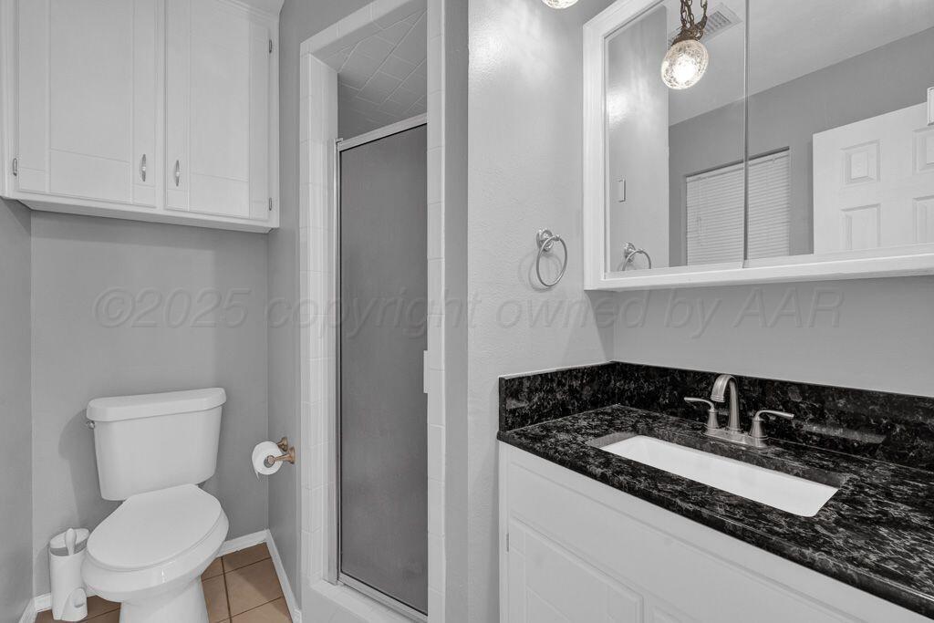 7935 Mitcham Drive Amarillo, TX 79121 - Photo 11 of 20 a bathroom with a granite countertop sink and a toilet