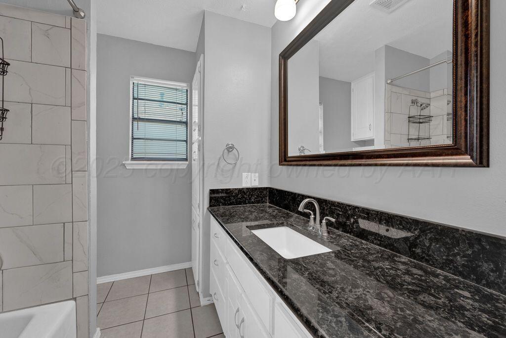7935 Mitcham Drive Amarillo, TX 79121 - Photo 14 of 20 a bathroom with a granite countertop sink and a mirror
