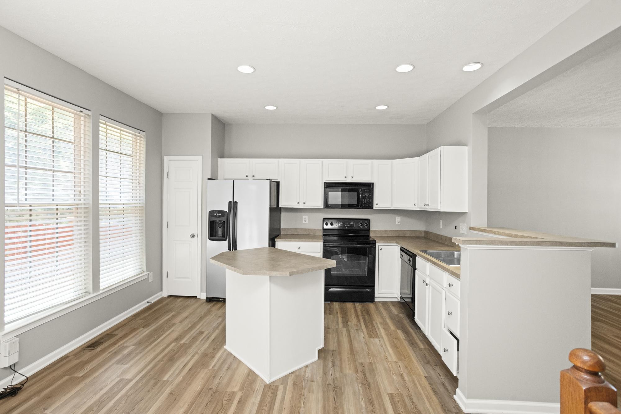 7277 Charlotte Pike, Unit 227 Nashville, TN 37209 - Photo 9 of 36 a kitchen with stainless steel appliances a stove top oven a sink a refrigerator white cabinets and wooden floor