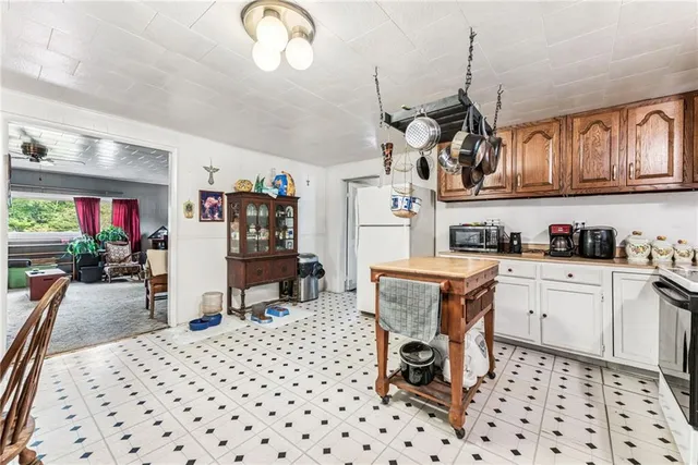 a kitchen with stainless steel appliances granite countertop a sink a stove a dining table and chairs with wooden floor