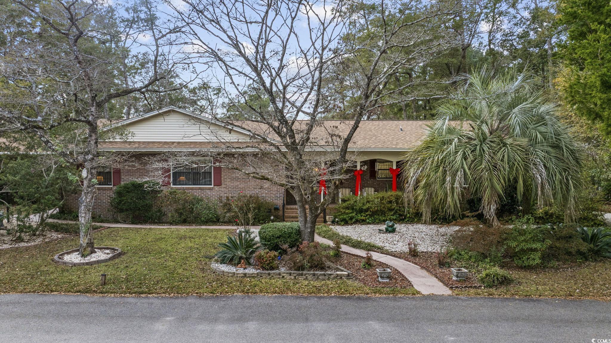 View of front of house featuring brick siding, a front yard, and a shingled roof