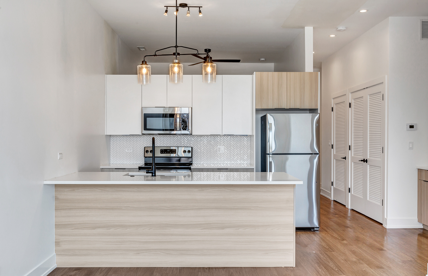 3312 North Halsted Street, Unit 2F Chicago, IL 60657 - Photo 5 of 17 a kitchen with kitchen island white cabinets and stainless steel appliances