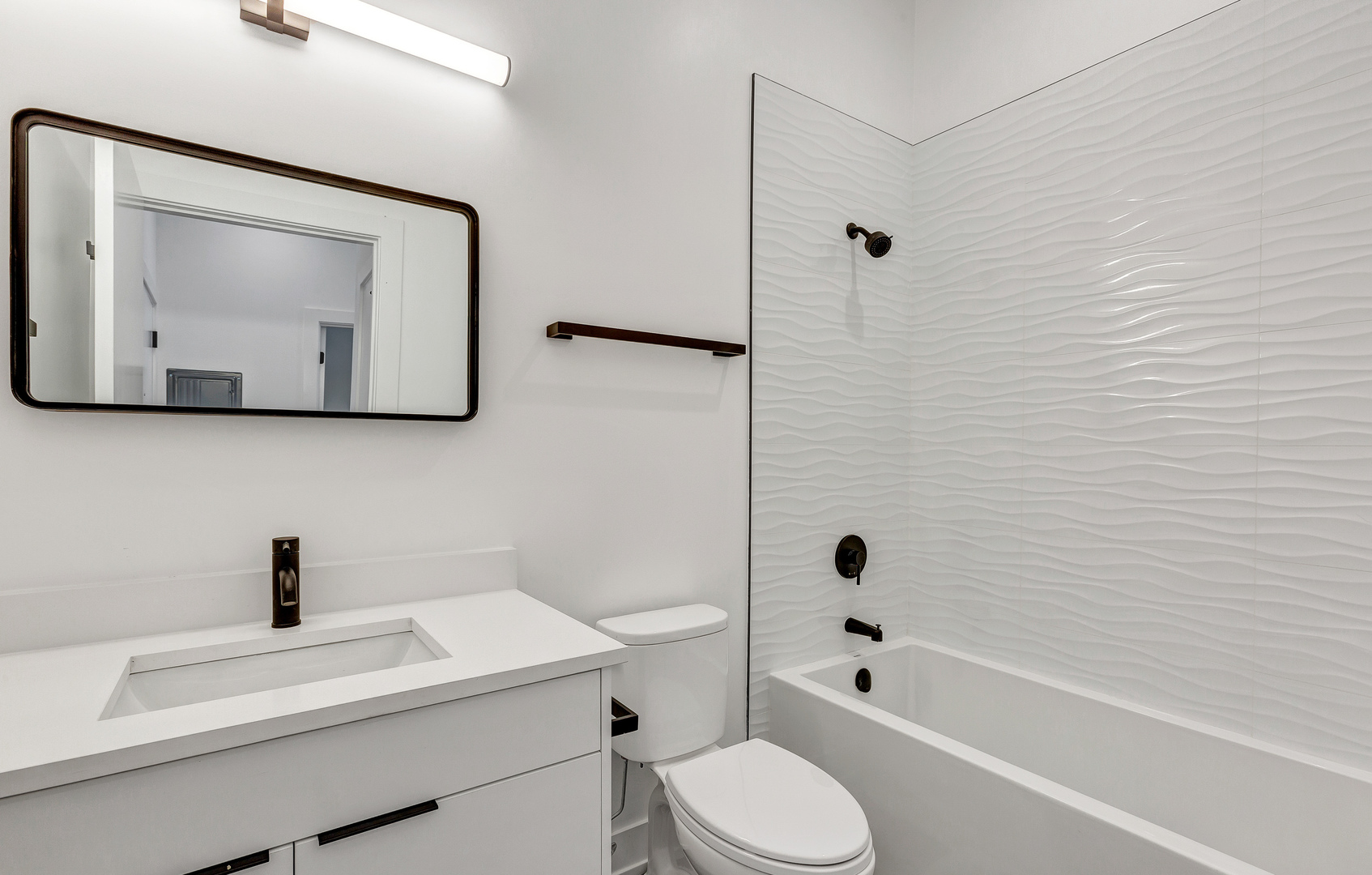 3312 North Halsted Street, Unit 2F Chicago, IL 60657 - Photo 8 of 17 a bathroom with a toilet sink a mirror a bathtub and vanity