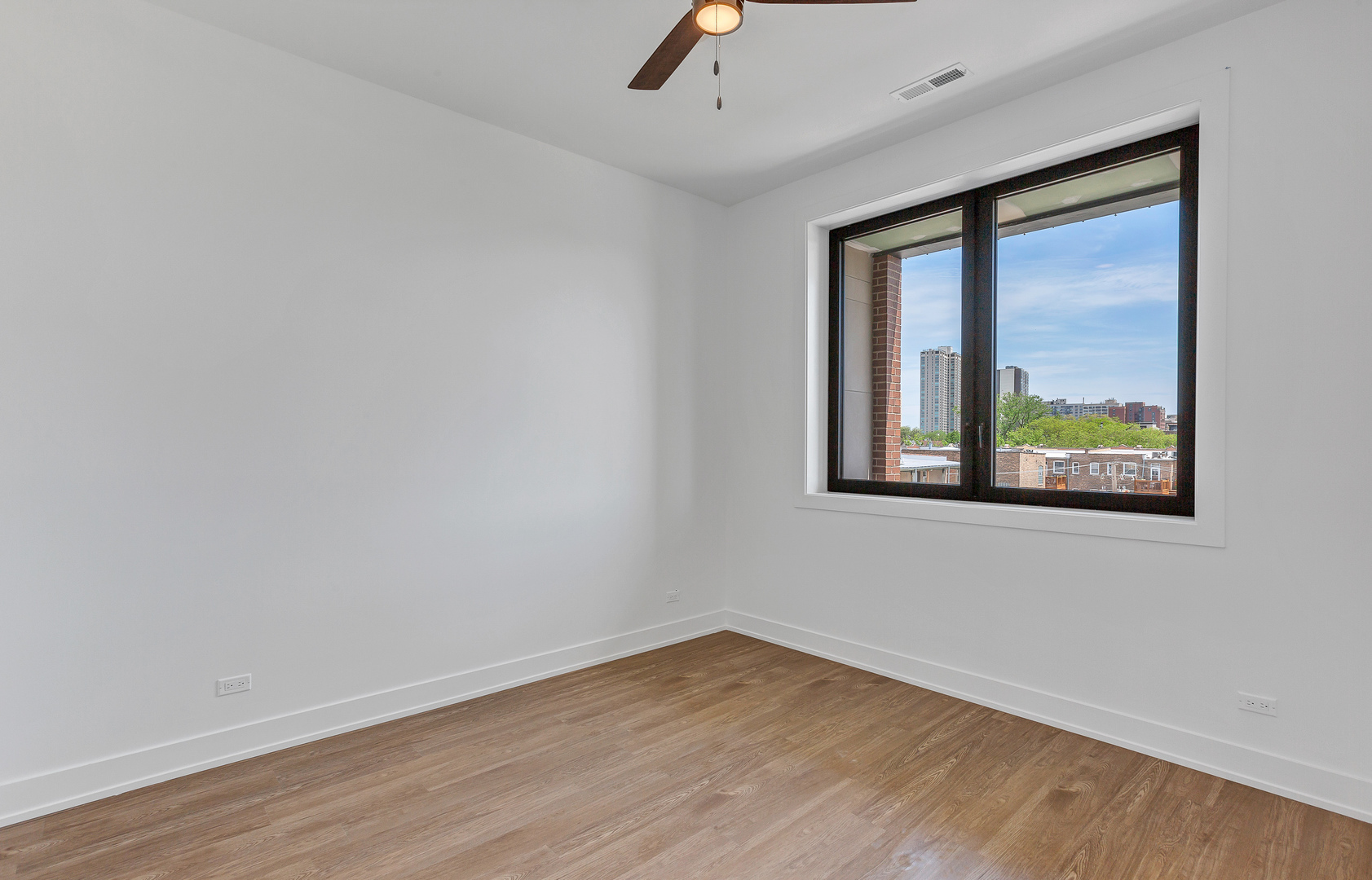 3312 North Halsted Street, Unit 2F Chicago, IL 60657 - Photo 9 of 17 an empty room with wooden floor and windows