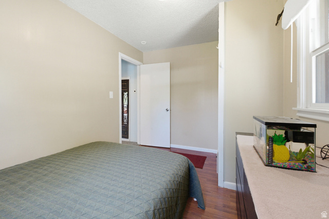 94 West 2000th Street North Clearfield, UT 84015 - Photo 9 of 26 Bedroom with neutral walls, warm flooring, and natural light from the window.