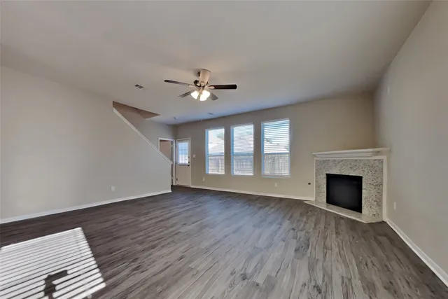 wooden floor fireplace and windows in an empty room