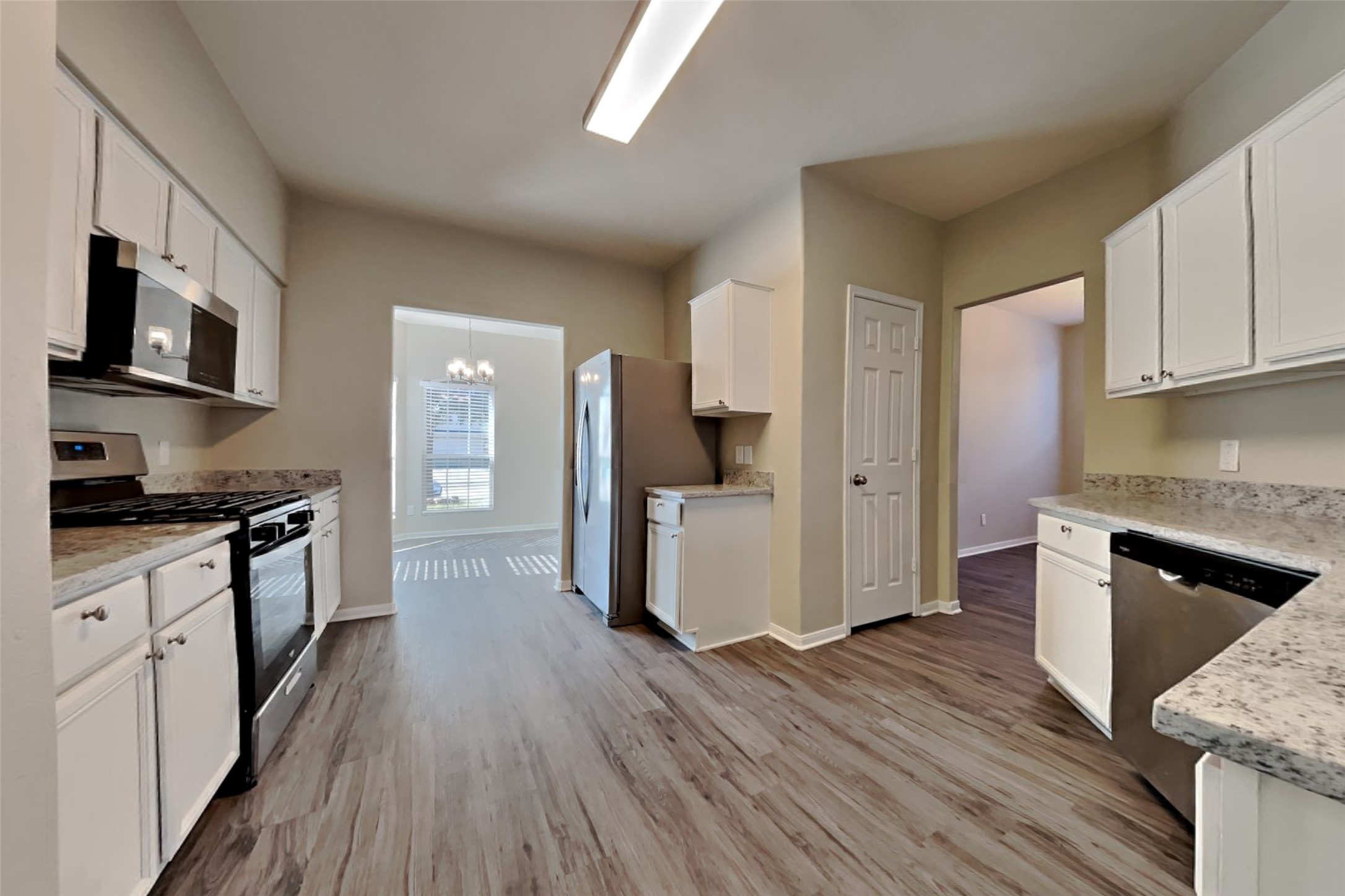2411 Lofty Falls Court Spring, TX 77386 - Photo 7 of 23 a large kitchen with cabinets wooden floor and stainless steel appliances