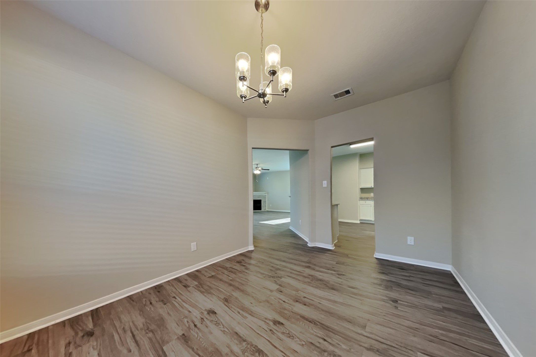 2411 Lofty Falls Court Spring, TX 77386 - Photo 10 of 23 a view of an empty room with wooden floor and a chandelier