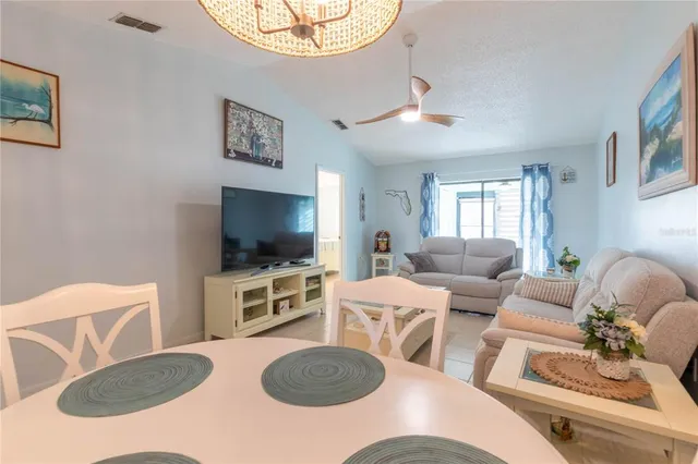 a living room with furniture a flat screen tv and a chandelier
