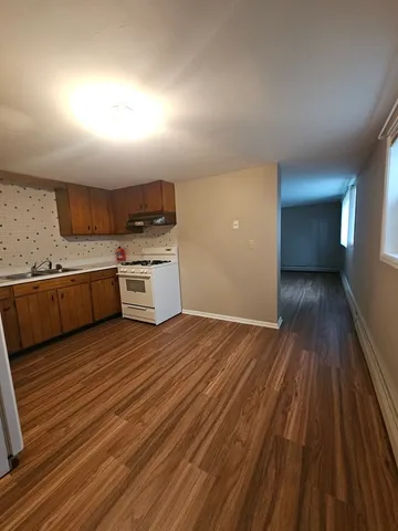 a kitchen with a sink and wooden floor