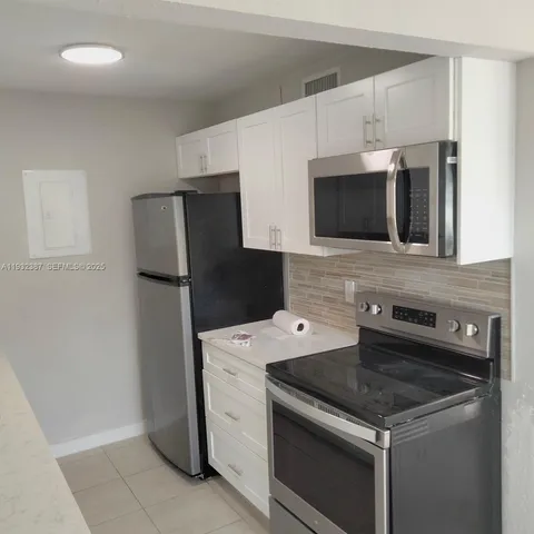 a kitchen with stainless steel appliances a stove microwave and refrigerator
