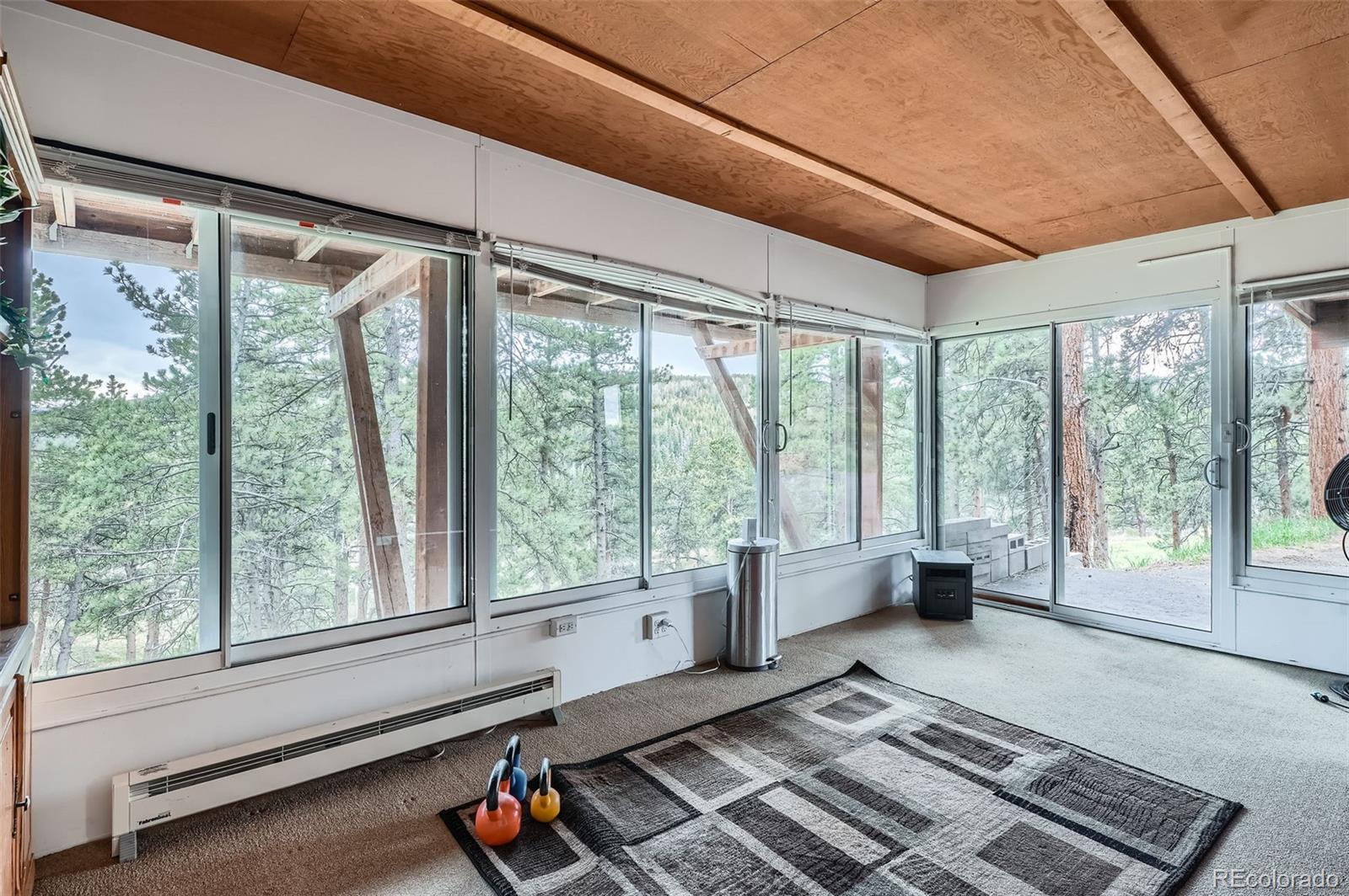 21191 Pleasant Park Road Conifer, CO 80433 - Photo 33 of 44 a living room with large windows