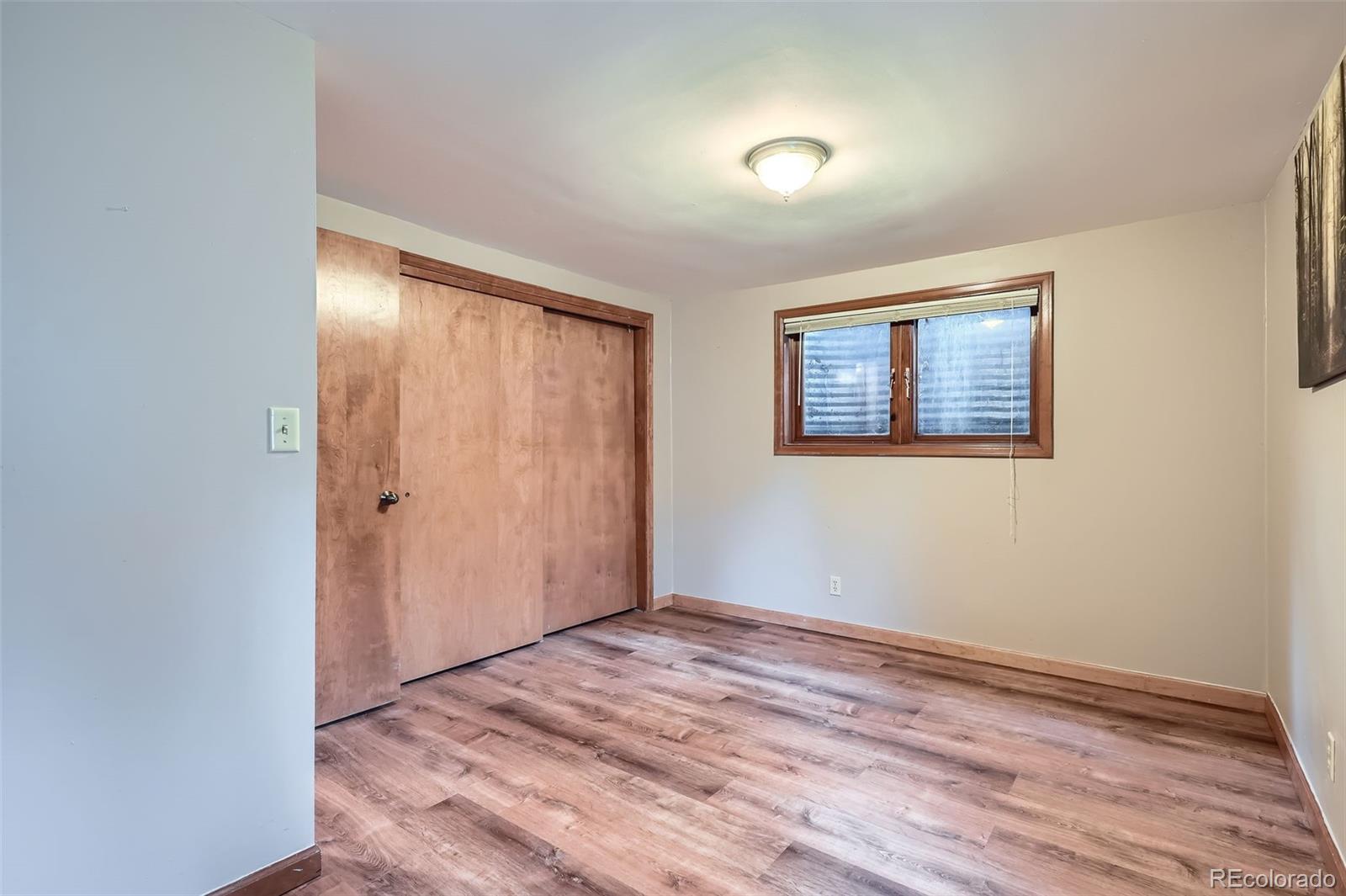 21191 Pleasant Park Road Conifer, CO 80433 - Photo 35 of 44 a view of an empty room with wooden floor and a window