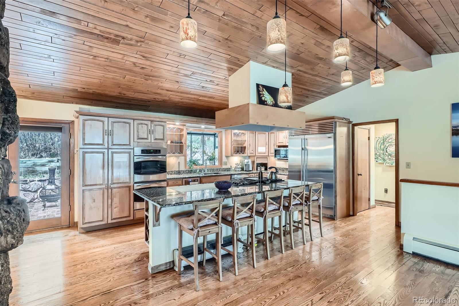 21191 Pleasant Park Road Conifer, CO 80433 - Photo 9 of 44 a kitchen with stainless steel appliances a table chairs refrigerator and cabinets
