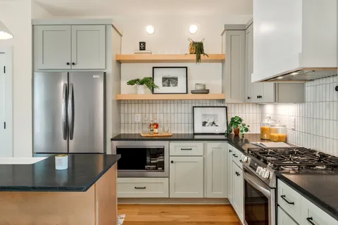a kitchen with stainless steel appliances granite countertop a stove a sink and a refrigerator