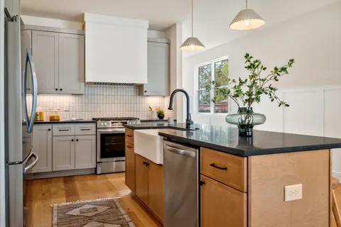 a kitchen with stainless steel appliances granite countertop a sink a stove and a refrigerator