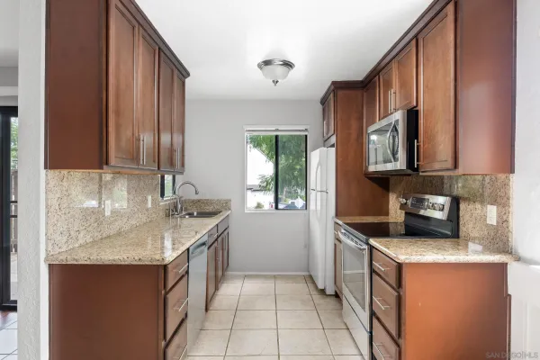 a kitchen with granite countertop a sink stove and cabinets
