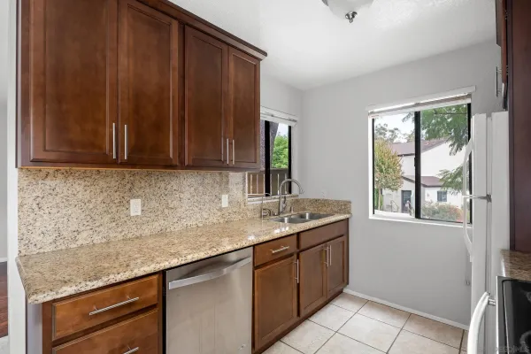 a kitchen with stainless steel appliances granite countertop wooden cabinets a sink and dishwasher