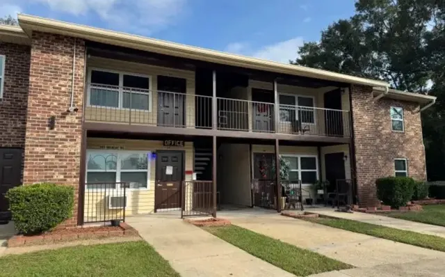 a front view of a house with a yard and potted plants