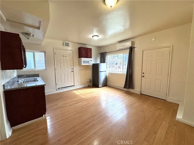 a view of a kitchen with wooden floor and electronic appliances