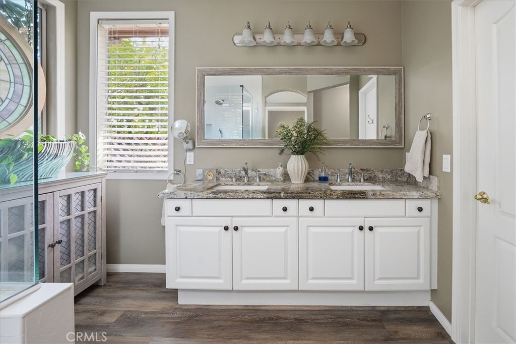 25808 Barnett Lane Stevenson Ranch, CA 91381 - Photo 16 of 38 a bathroom with a granite countertop sink a mirror and a window