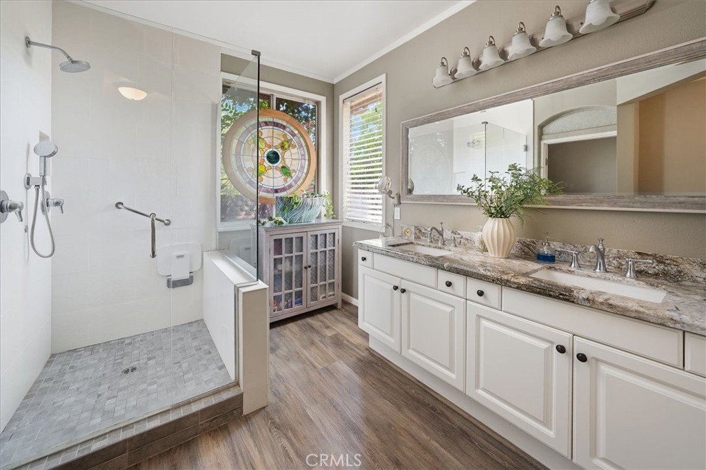 25808 Barnett Lane Stevenson Ranch, CA 91381 - Photo 17 of 38 a spacious bathroom with a granite countertop sink a mirror a vanity and a shower
