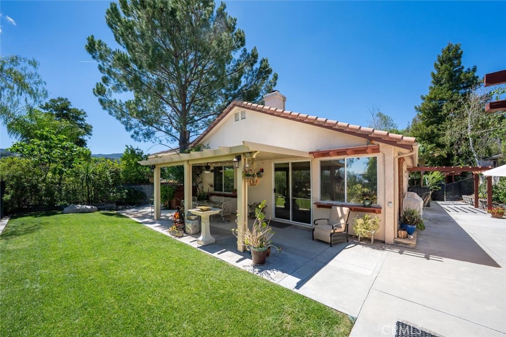25808 Barnett Lane Stevenson Ranch, CA 91381 - Photo 26 of 38 a view of a patio with table and chairs under an umbrella