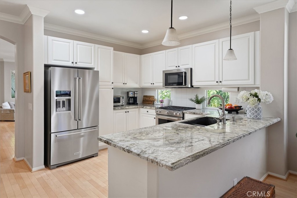 25808 Barnett Lane Stevenson Ranch, CA 91381 - Photo 4 of 38 a kitchen with kitchen island granite countertop a refrigerator oven a sink and cabinets