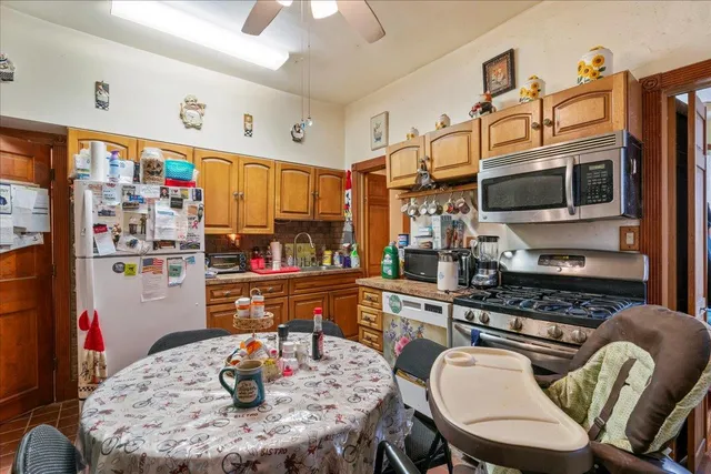 a kitchen with stainless steel appliances granite countertop a dining table and chairs with wooden floor