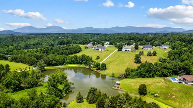 a kitchen with stainless steel appliances kitchen island granite countertop a refrigerator a stove top oven and a dining table with wooden floor