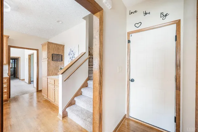 a view of a hallway with wooden floor and staircase