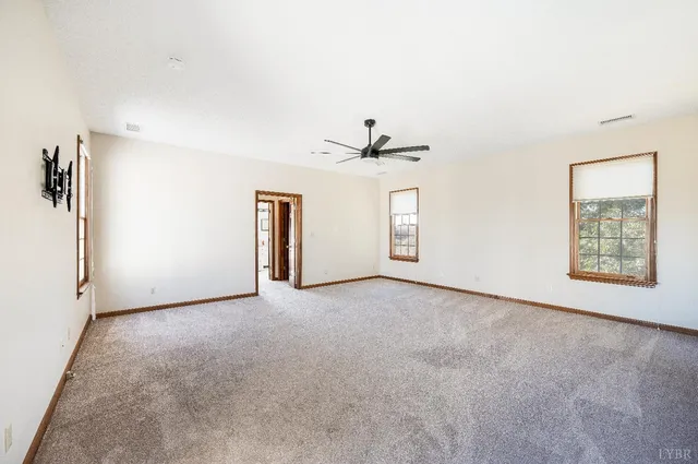 an empty room with closet and a ceiling fan