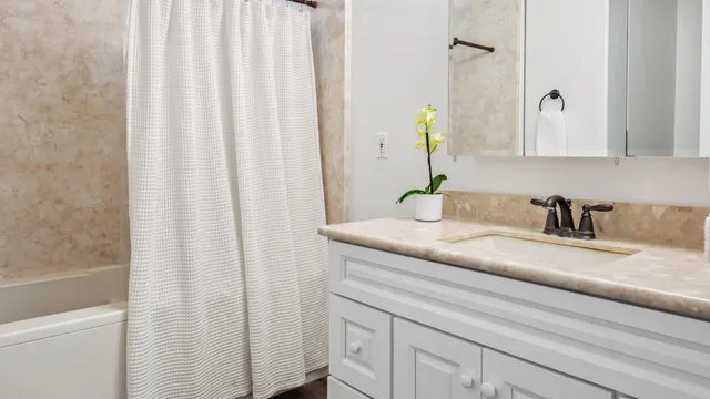 a bathroom with a granite countertop sink and a mirror