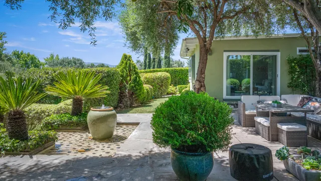 a view of a backyard with garden and patio