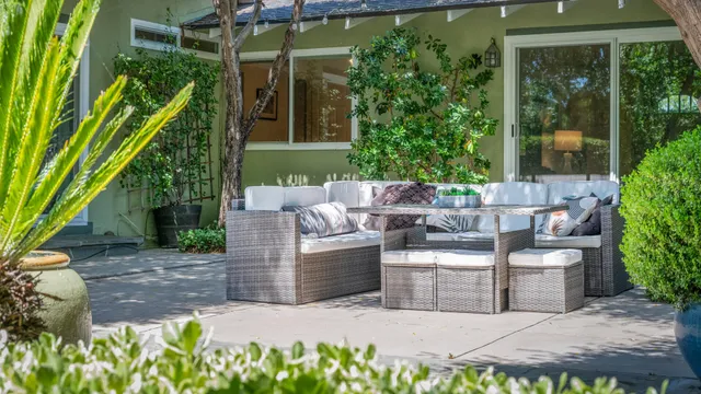 a view of a patio with couches table and chairs and potted plants