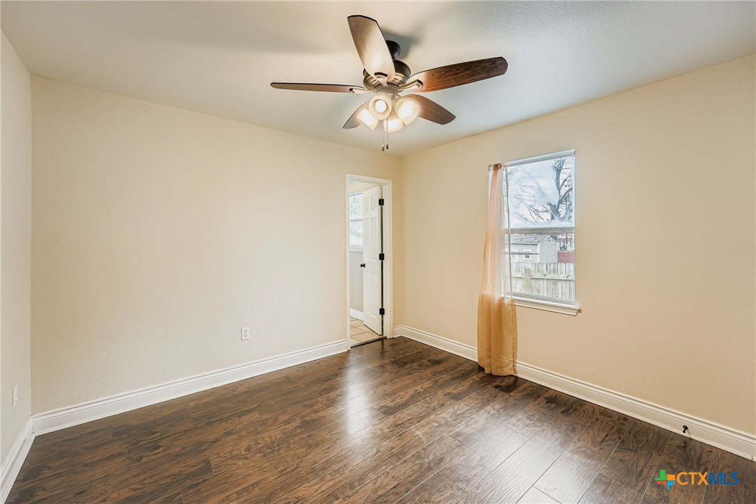304 South Main Street Elgin, TX 78621 - Photo 19 of 25 Bedroom #2 with dark wood finished floors and ceiling fan