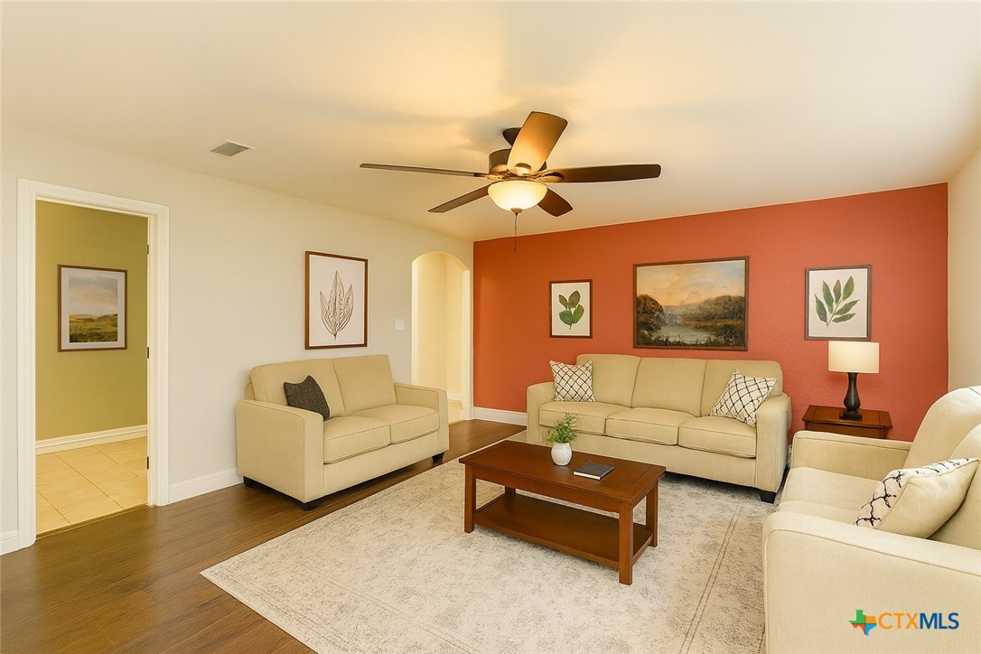 304 South Main Street Elgin, TX 78621 - Photo 2 of 25 Virtually staged - Living area featuring arched walkways, wood finished floors, and ceiling fan