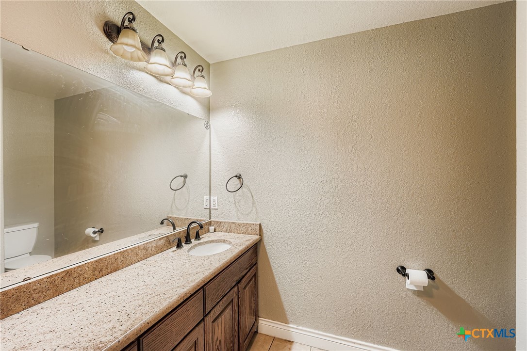 304 South Main Street Elgin, TX 78621 - Photo 21 of 25 Bathroom with vanity, tile flooring and a textured wall