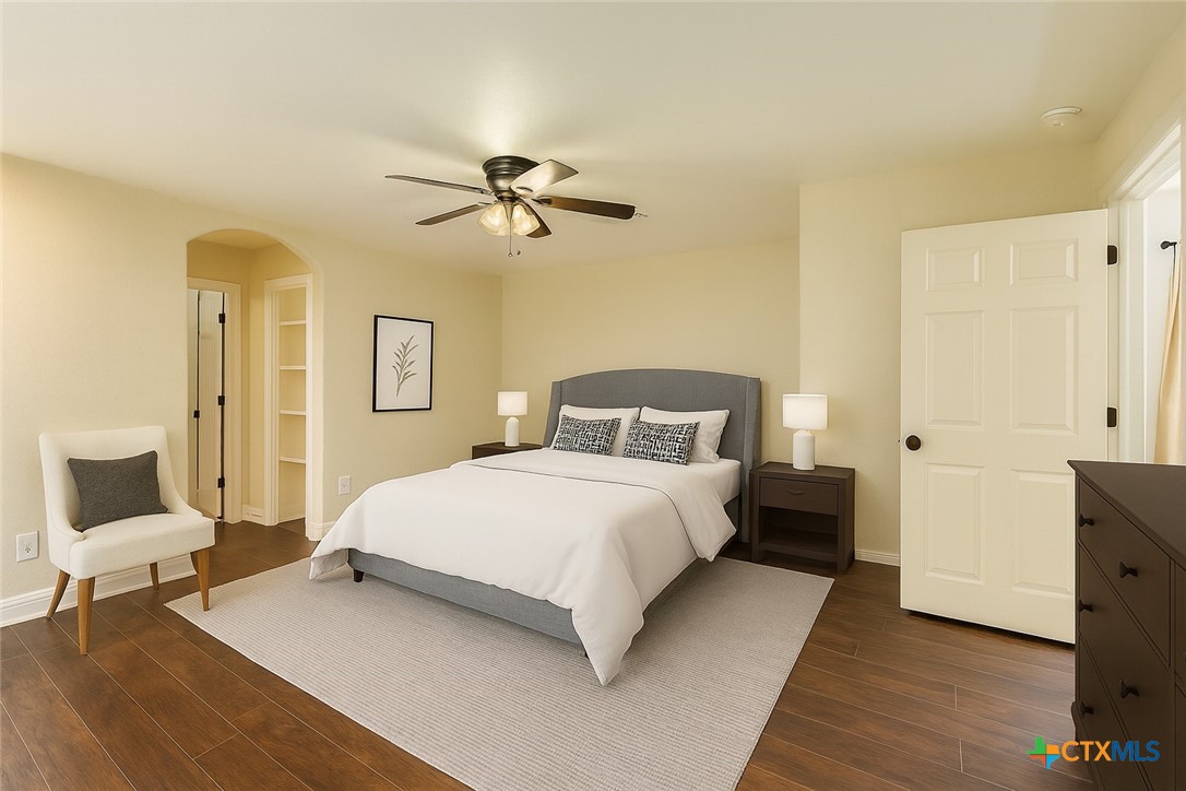 304 South Main Street Elgin, TX 78621 - Photo 3 of 25 Virtually staged - Bedroom with dark wood-type flooring, ceiling fan, and arched walkways