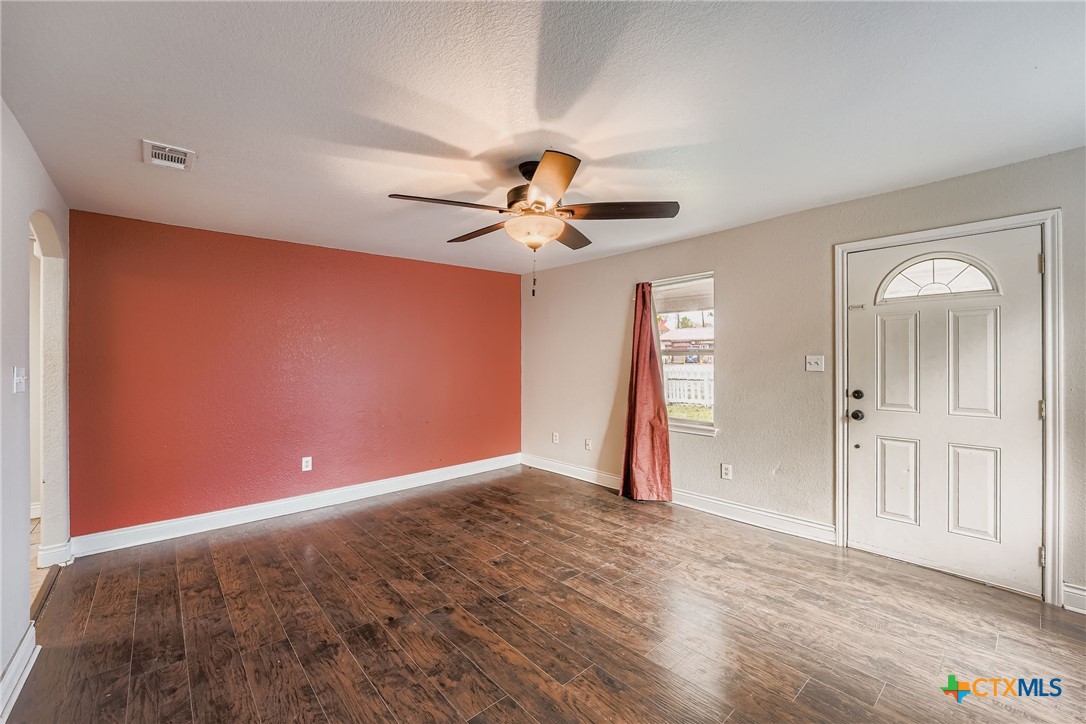 304 South Main Street Elgin, TX 78621 - Photo 8 of 25 Entry with dark wood finished floors, ceiling fan, and a textured ceiling