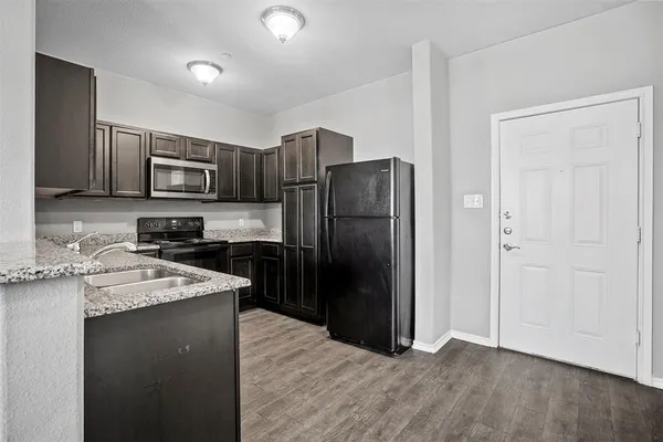 a kitchen with stainless steel appliances granite countertop a refrigerator stove and sink